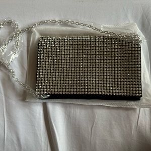 black purse with rhynestones with a silver chain strap.